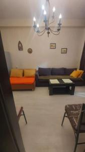 a living room with a couch and a table at Уютная и светлая квартира с видом на горы in Tbilisi City