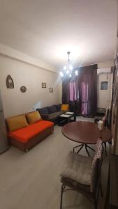 a living room with a couch and a table at Уютная и светлая квартира с видом на горы in Tbilisi City
