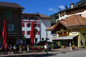 a group of buildings with red umbrellas on a street at Ciasa Buro - Ron in Moena