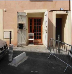 a door to a building with a chair in front of it at "Pascal 1" Eglise St Louis - Studio Cosy Quartier Haut in Sète
