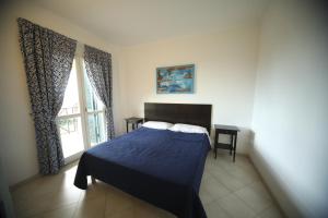 a bedroom with a blue bed and a window at La Vista Agriturismo Boutique in Ariccia