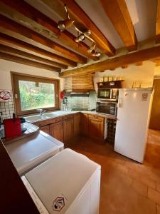 a kitchen with a white refrigerator and a window at Eden Cottage in Saint-Gâtien-des-Bois