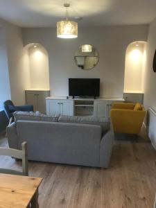 a living room with a couch and a television at Eyre Luxury Apartment in Galway