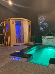 a swimming pool in a room with a tiny house at Pasithéa Loft Spa Privatif in Calais
