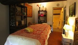 a bedroom with a bed with a red and white blanket at Fontaine des Magnarelles in Althen-des-Paluds