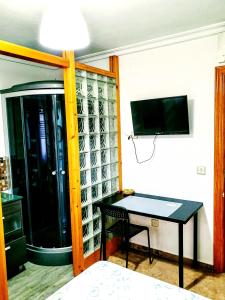 a room with a table and a tv on a wall at Iberos Jaén in Jaén