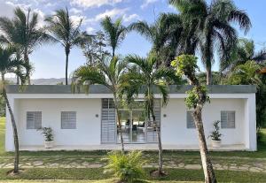 une maison blanche avec des palmiers devant elle dans l'établissement Serafina Organic Farm®, à Jamao al Norte