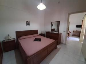 a bedroom with a large bed with a pink blanket at Appartamenti Vacanza al centro in Pantelleria