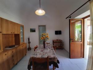 a dining room with a table with flowers on it at Appartamenti Vacanza al centro in Pantelleria