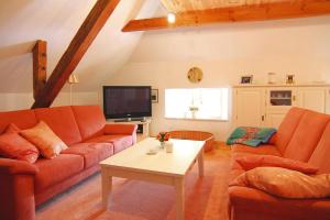 a living room with orange couches and a tv at Apartment Dycke House, Zudar in Zudar