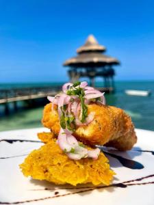 a piece of food on a plate next to the ocean at El Embrujo Tintipan in Tintipan Island