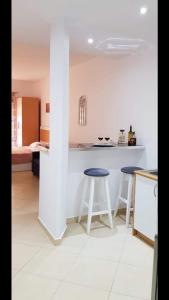 eine Küche mit zwei Hockern und einer weißen Arbeitsplatte in der Unterkunft Studio by the beach - Vlore in Vlorë