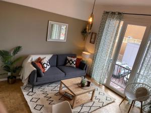 uma sala de estar com um sofá azul e uma mesa em Garibaldi 3 chambres 6 couchages, EASY CHECK-IN em Nice