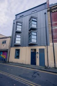 a gray building with a blue door on a street at Bedminster Parade in Bristol