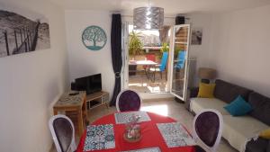 a living room with a table and a couch at Grandes Bleues, Appartement T3 duplex, piscine, Narbonne Plage in Narbonne-Plage +8 photos