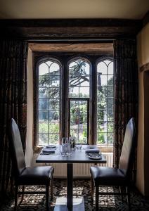 uma sala de jantar com uma mesa e cadeiras em frente a uma janela em Fawsley Hall Hotel em Daventry