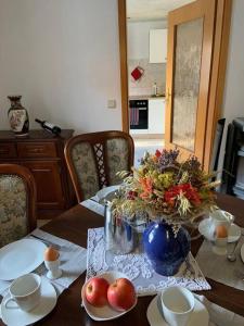 uma mesa de jantar com um vaso de flores e frutas em FerienGnevkow45 - Mit dem Zug direkt ins Grüne - Entspannung inklusive em Gnevkow
