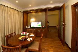 uma sala de jantar com uma mesa e uma televisão em Clarion Bella Casa at Airport em Jaipur