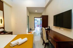 a hotel room with a bed and a flat screen tv at Grande Alpine Hotel in Vagator