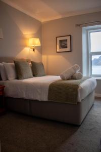 a bedroom with a large bed with a window at The Rosedale Hotel & Restaurant in Portree