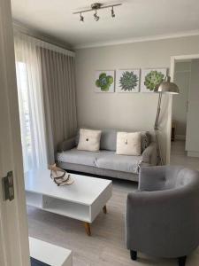 a living room with a couch and a coffee table at Paragon Domain Light and Airy Stylishly Decorated in Cape Town