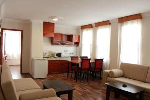 a living room with a couch and a table and a kitchen at Luxor apartments in Alanya