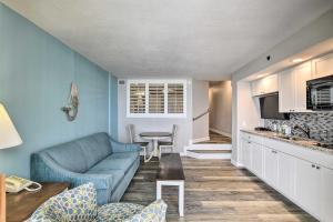 a living room with a blue couch and a kitchen at Oceanfront North Myrtle Beach Condo with Views! in Myrtle Beach