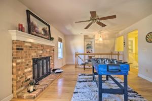 a living room with a brick fireplace and a table at Pet-Friendly Cottage with Game Room and Fire Pit! in Syria