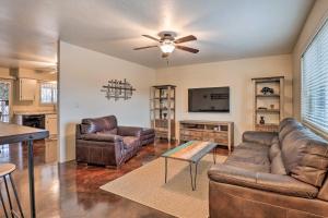 sala de estar con muebles de cuero y ventilador de techo en Sunny Tucson Abode with Fire Pit 9 Mi to U of A, en Tucson