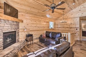 a living room with a leather couch and a fireplace at Duck Creek Village Cabin with Fire Pit and Grill! in Duck Creek Village