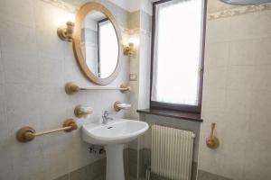 baño con lavabo, espejo y ventana en Mountain Hut Veronza, en Cavalese