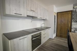 a kitchen with white cabinets and a sink and a counter at Mountain Hut Veronza in Cavalese