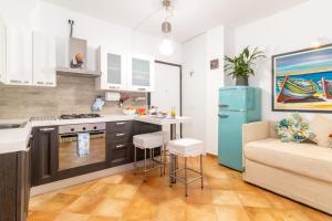 Il dispose d'une cuisine et d'un salon avec un réfrigérateur et un canapé. dans l'établissement Residence Dei Fiori, à Santa Teresa Gallura
