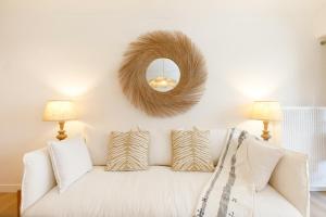 uma sala de estar com um sofá branco e um espelho em Hippie Palm Beach YourHostHelper em Cannes