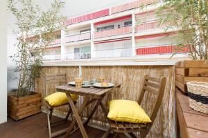 uma pequena mesa e cadeiras numa varanda com um edifício em Hippie Palm Beach YourHostHelper em Cannes