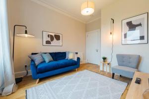 a living room with a blue couch and a chair at The Trossachs Apartment in Stirling