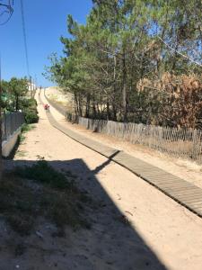 a road with a fence on the side of it at A 200m de la plage - L'Océan - in Mimizan-Plage