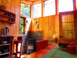 sala de estar con mesa y chimenea en Refugio Montaña Kultrun Mawida, Habitación con baño y cocina privada, en Curacautín