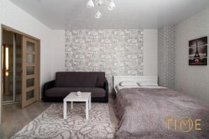 a bedroom with a bed and a couch and a table at Apartment with a beautiful view lxt by in Grodno