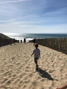 a young child running on the beach at A 200m de la plage - L'Océan - in Mimizan-Plage