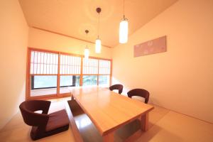 uma sala de jantar com uma mesa de madeira e cadeiras em Ryotei Hanayura em Noboribetsu