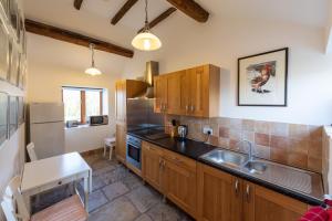 a kitchen with wooden cabinets and a stainless steel refrigerator at Whitley Coach House in Whitley