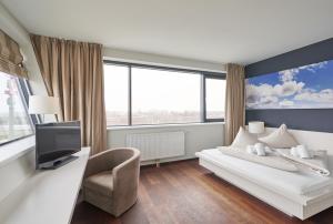 a hotel room with a bed and a tv at Rosenberger Seminar-Hotel Deutsch-Wagram in Deutsch-Wagram