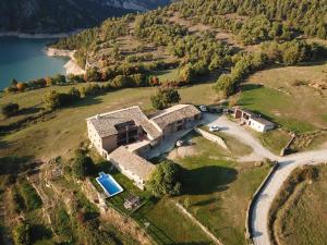 an aerial view of a house on a hill next to a lake at Cases Altes de Posada in Navés