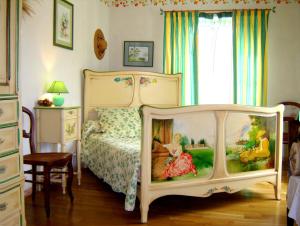 Un dormitorio con una cama con una pintura. en Autrefois La Modiste, en Saint-Clar