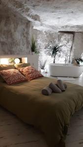 una camera da letto con un grande letto con due asciugamani di La Trog'Laudy gîte 4 étoiles au coeur des vignes a Vouvray