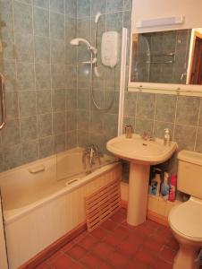 a bathroom with a sink and a tub and a toilet at Belmont Cottage in Dumfries +15 photos