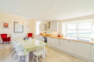 a kitchen and dining room with a table and chairs at Dourie Farmhouse in Port William