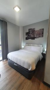 1 dormitorio con 1 cama blanca grande en una habitación en H La Cabaña en Pozuelo de Alarcón