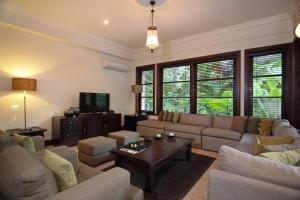 sala de estar con sofá y TV en Villa Surya, en Tanah Lot